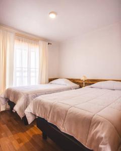 2 camas en un dormitorio con ventana en Cabaña el Mirador Caleuche., en Chañaral
