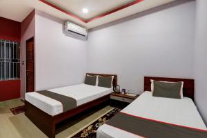 two beds in a room with red and white walls at Super Collection O Ashirbad Lodge in Guwahati