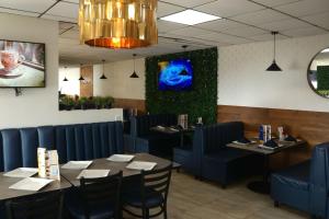 une salle à manger avec des tables et des chaises bleues dans l'établissement Hotel Jatay, à Tijuana