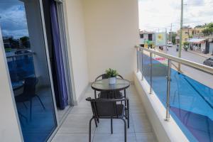 d'un balcon avec une table, des chaises et une piscine. dans l'établissement JOMYS HOTEL en Higüey, à Higuey