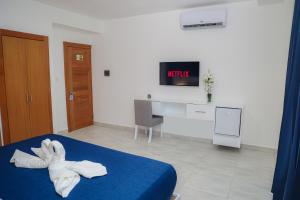 Cette chambre comprend un lit avec un animal de serviettes. dans l'établissement JOMYS HOTEL en Higüey, à Higuey