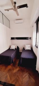 a room with two beds and a ceiling fan at Baireshistorico in Buenos Aires
