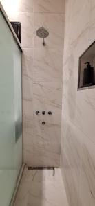 a bathroom with a shower with white marble walls at Baireshistorico in Buenos Aires +15 photos