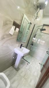 uma casa de banho com um lavatório branco e um espelho. em Majorstone Luxury Apartment em Ibadan