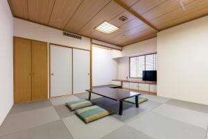 ein Wohnzimmer mit einem Tisch und einem TV in der Unterkunft Court Hotel Asahikawa in Asahikawa