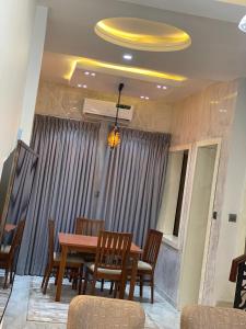 a dining room with a wooden table and chairs at Majorstone Luxury Apartment in Ibadan