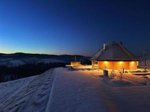 a wooden cabin in the snow at night at Heavenly Houses - Niebiańskie Domki in Jaworzynka
