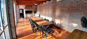 a long table and chairs in a room with a brick wall at La Perla in General Alvarado
