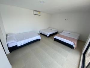 CABAÑA PARA VACACIONAR EN SABANAGRANDE في Sabanagrande: غرفة بثلاث اسرة في غرفة