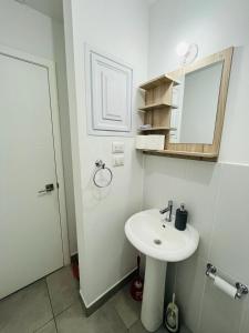 Baño blanco con lavabo y espejo en Apartamento zona 4, Ciudad de Guatemala, en Guatemala