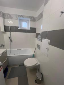 een badkamer met een toilet, een bad en een wastafel bij Apartament Zasanie 2 Przemyśl in Przemyśl