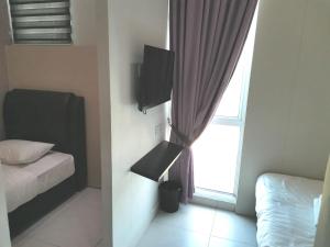 a bedroom with a bed and a window at TT99 COZY STAY in Miri