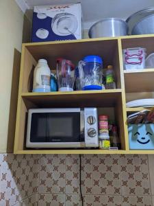 einen Schrank mit einer Mikrowelle in der Küche in der Unterkunft Cozy House, Quiet Area Kimandolu in Arusha