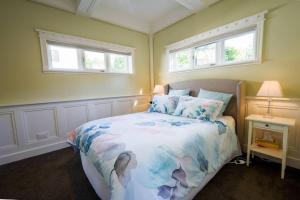 a bedroom with a bed and two windows at By the Beach Coastal Cabin with Hot Tub in Cowes