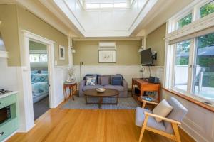 a living room with a couch and a table at By the Beach Coastal Cabin with Hot Tub in Cowes