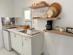 a kitchen with white cabinets and a sink at CASA ELEO in Arrecife