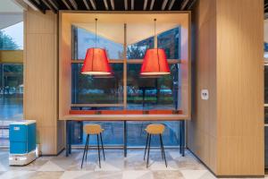 two red lights above a bar with two stools at Holiday Inn Express Xiamen Jimei New Town, an IHG Hotel in Xiamen