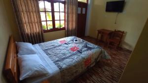 ein Schlafzimmer mit einem Bett und einem Tisch darauf in der Unterkunft Hospedaje El Manantial in Oxapampa