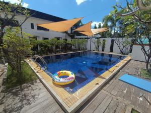 an empty swimming pool with an inflatable raft and an umbrella at Bella Vista Apartments in Kampot