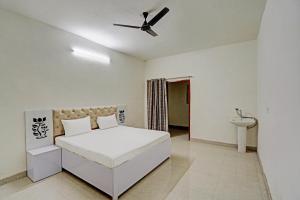 a white bedroom with a bed and a ceiling fan at Super OYO Chawla's Hotel & Restaurant in Gurgaon