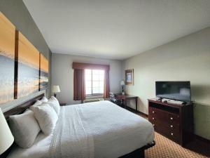a hotel room with a bed and a flat screen tv at Days Inn by Wyndham Kemah in Kemah