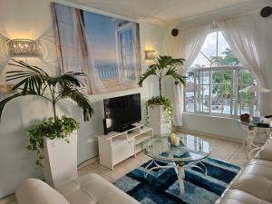 a living room with a couch and a tv and a table at Blue Topaz in Ocho Rios