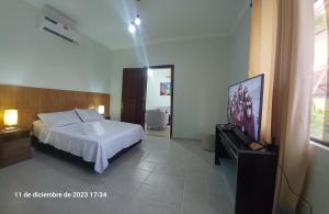 1 dormitorio con 1 cama y TV en Lirios Apartment in EQUIPETROL - With parking, en Santa Cruz de la Sierra