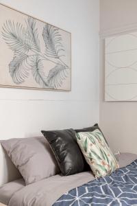 a bed with two pillows and a picture on the wall at Boutique Private Room near Sydney Airport - Guesthouse in Sydney