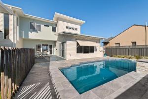a swimming pool in front of a house at Sea Sand and Serenity at Stockton - Stunning Sophistication in Stockton