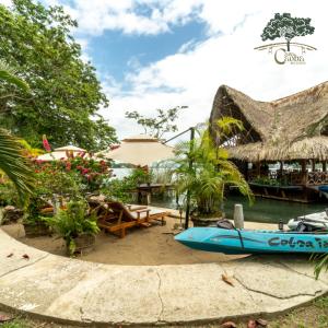 un bateau assis sur le sable devant un restaurant dans l'établissement Casa Caoba RD, à Rio Dulce