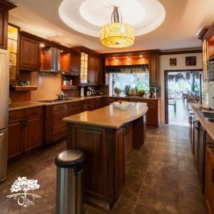 a large kitchen with wooden cabinets and a large island at Casa Caoba RD in Rio Dulce