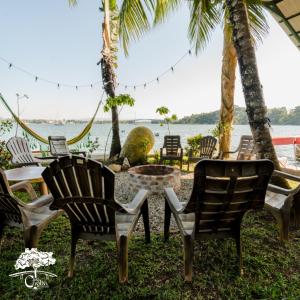 a group of chairs and a table in front of the water at Casa Caoba RD in Río Dulce