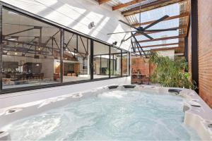 a hot tub in a room with large windows at Platinum Precinct - The Penthouse in Newcastle
