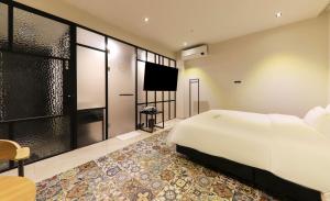 Den Basta hotel في Yangsan: غرفة نوم بسرير ابيض كبير وتلفزيون