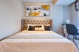 a bedroom with a large bed with a large headboard at Apartment Roseville SOHO & Suites by Nagisa Bali in Dadap