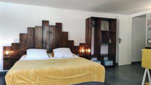 a bedroom with a large bed with a wooden headboard at Les Coulirooms - Gîte in Sainte-Anne