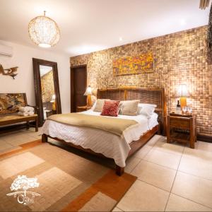 een slaapkamer met een bed en een bakstenen muur bij Casa Caoba RD in Rio Dulce