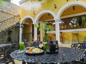 a table with a plate of food and a bottle of wine at Xkopek, Camping y Cabañas in Valladolid