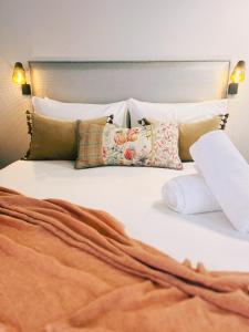 1 cama con almohadas y colcha blanca en Kurow Motel en Kurow