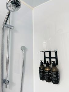 a group of four bottles sitting on a shelf in a shower at Kurow Motel in Kurow
