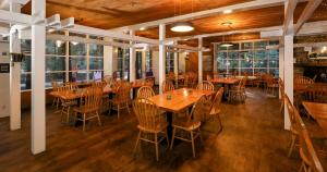 un ristorante con tavoli e sedie in legno e finestre di Big Sur Lodge a Big Sur