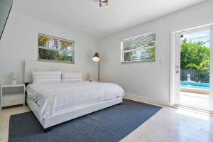 a white bedroom with a bed and a window at Perfect Beach Home For A Family Getaway Wpool! in Miami Beach