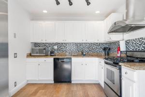 a kitchen with white cabinets and a black dishwasher at Perfect Beach Home For A Family Getaway Wpool! in Miami Beach