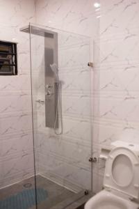 a bathroom with a glass shower with a toilet at Sleek Luxury Homes in Kumasi