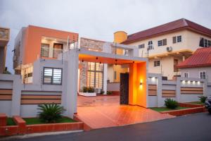 una casa con una entrada naranja delante de ella en Sleek Luxury Homes, en Kumasi