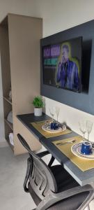 a table with two glasses and a tv on a wall at Loft 3 Novo 5 min aeroporto Marabá in Marabá