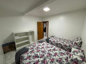1 dormitorio con 1 cama con manta de flores en Aptos Weber - Piratini, en Gramado