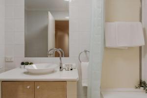 La salle de bains est pourvue d'un lavabo et d'un miroir. dans l'établissement Central 2-Bed with Gym and Secure Parking, à Canberra