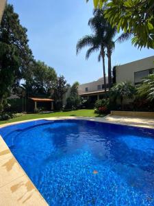 une grande piscine bleue en face d'un bâtiment dans l'établissement Casa Don Pancho, à Cuernavaca