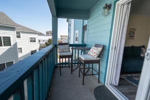 a balcony with chairs and a table and a couch at Portabella Paradise in Carolina Beach